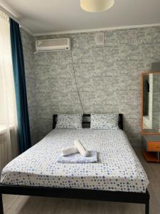 1 dormitorio con 1 cama con 2 toallas en Hotel FRESH, en Aktobe