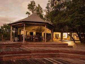 - un pavillon avec une table et des chaises sur une terrasse dans l'établissement Muzimu Lodge, 