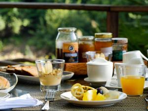 une table recouverte de assiettes de nourriture et de verres de jus d'orange dans l'établissement Muzimu Lodge, 