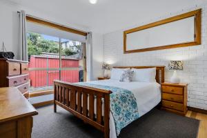 1 dormitorio con cama y ventana grande en Lavender Cove, en Kingston Beach