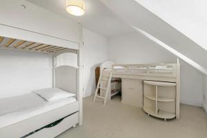 a white bedroom with a bunk bed and a desk at Richmond Oasis - Pass The Keys in London