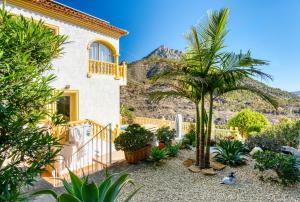 a house with a palm tree and a mountain at Lujosa Calpe in Calpe