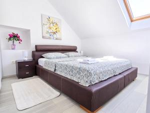 a bedroom with a large bed with a brown couch at Stone House Varos Apartments in Split