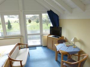 a bedroom with a bed and a television and a table at Gästehaus Steker in Bad Driburg