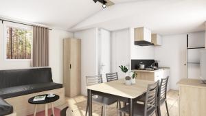 een woonkamer en een keuken met een tafel en stoelen bij Camping Le Clos Des Pins in Longeville-sur-Mer