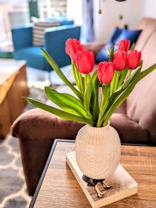 a vase filled with red tulips sitting on a table at Villa Seewind Whg 18 Hühnergott in Dahme