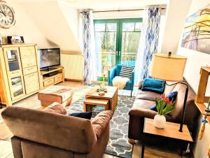 a living room with two couches and a tv at Villa Seewind Whg 18 Hühnergott in Dahme