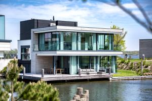 a house on the water with a dock at Dormio Harbour Village in Arnemuiden