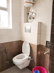 a bathroom with a toilet and a chandelier at Roomshala 160 Hotel Red - Vasant Kunj in New Delhi