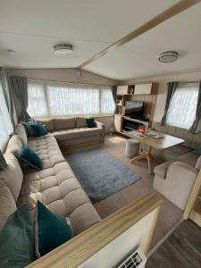 ein Wohnzimmer mit Sofa und Tisch in der Unterkunft Spacious and modern - 134 UNITY BEACH HOLIDAY RESORT UNITY BREAN CENTRALLY LOCATED 6 birth 2 Pets stay free in Brean