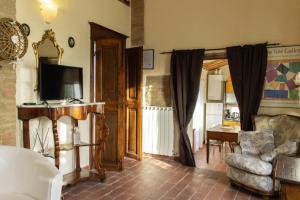 ein Wohnzimmer mit einem Sofa, einem Stuhl und einem TV in der Unterkunft Appartamenti Starebene A Siena in Siena