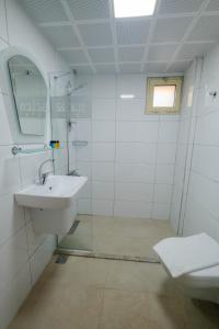 a white bathroom with a sink and a mirror at Club Selen icmeler in Marmaris