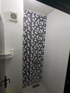 y baño con ducha y pared estampada. en perfect place in Casa but not too close, great transportation and 5km to the beach and shops all around trams, buses, train, en Casablanca