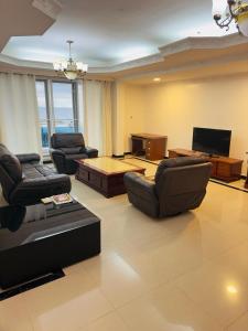 una gran sala de estar con sofás y TV. en The View Apartment, en Dar es Salaam