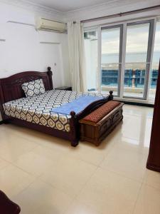 1 dormitorio con 1 cama en una habitación con ventanas en The View Apartment, en Dar es Salaam