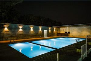 a large blue swimming pool at night at Sree Lalitha Resort and Convention in Shamirpet