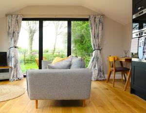 uma sala de estar com um sofá e uma mesa em The Cabin at the Croft - Idyllic rural retreat perfect for couples and dogs em Leigh