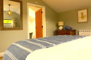 1 dormitorio con cama y espejo en The Cabin at the Croft - Idyllic rural retreat perfect for couples and dogs, en Leigh