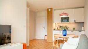 a kitchen and a living room with a table at Apartament RAINBOW SurfingBird Dźwirzyno in Dźwirzyno