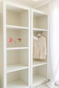 a white closet with white shelves and a shirt at Alexandros Apartments in Naousa