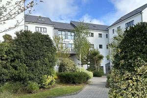 a large white building with bushes in front of it at Canvas Cúirt na Coiribe Galway in Galway