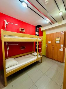 2 łóżka piętrowe w pokoju z czerwoną ścianą w obiekcie Envoy Hostel & Tours w Erywaniu