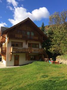 a large wooden house with a lawn in front of it at La Cucumelle in La Salle-les-Alpes