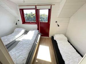 two beds in a small room with a window at Seaside apartment - A9 in Nautnes