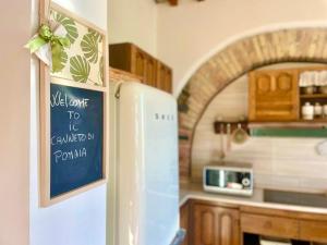 una cocina con nevera con un cartel. en Il Canneto Di Pomaia, en Pomaia