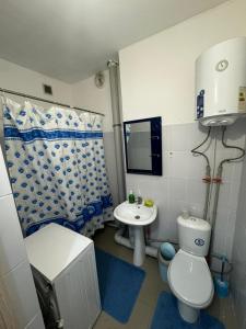 a small bathroom with a toilet and a sink at Comfort Turkestan in Türkistan