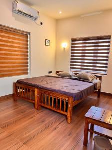 1 dormitorio con 1 cama grande en una habitación con ventana en Chittattinkara Ayurvilla Traditional wellness Retreat, en Trivandrum