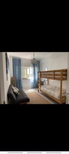 a bedroom with a bed and a couch in it at Soltroia Dunas House in Troia