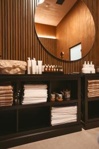 um quarto com um espelho e uma prateleira com toalhas em ALLEGRIA HOTEL Spa em Baile Unu Mai