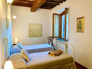 1 dormitorio con 2 camas y ventana en Il Canneto Di Pomaia, en Pomaia