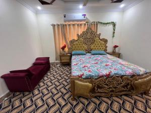 a bedroom with a large bed and a chair at Home in Islamabad in Islamabad