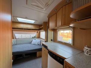 a kitchen in an rv with a couch in it at Przyczepy Kempingowe OSK LOK by Q4Camp in Jastarnia