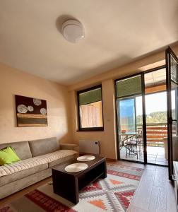 兹拉蒂博尔Apartman Daroteka的客厅里有一张沙发和一张桌子。