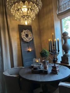 a dining room with a table with candles and a chandelier at Bed and Breakfast Lokaal Wadway in Spanbroek