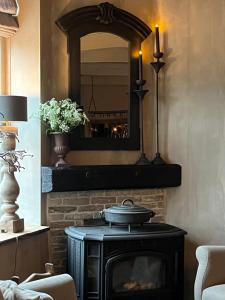 a fireplace in a living room with a mirror at Bed and Breakfast Lokaal Wadway in Spanbroek
