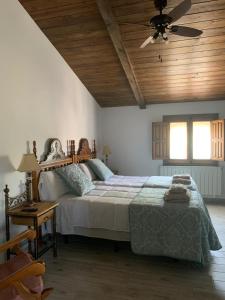 a bedroom with a large bed with a wooden ceiling at Villa rural de campo aldea Las Zorizas in Munera