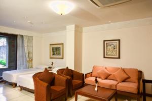 una camera d'albergo con letto e divano di The Patra Bali Resort & Villas - CHSE Certified a Kuta