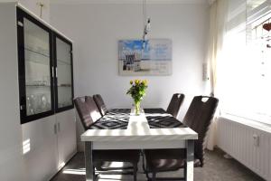 a dining room table with chairs and a vase of flowers on it at FeWo Kiek-mol-wedder-in Whg5 in Dahme