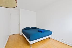 een slaapkamer met een bed met een blauwe deken bij Appartement Quartier Tour Eiffel 4 in Parijs
