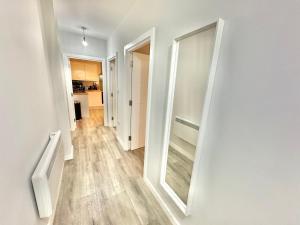 a hallway with a mirror on the wall at Spacious One Bedroom Apartment - With Parking and WiFi - Town Centre Location - Gated Access - Walk to Beach! in Bournemouth +5 photos