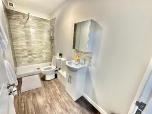 a white bathroom with a toilet and a sink at Spacious One Bedroom Apartment - With Parking and WiFi - Town Centre Location - Gated Access - Walk to Beach! in Bournemouth