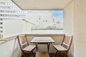 een tafel en 2 stoelen op een balkon bij Appartement Quartier Tour Eiffel 4 in Parijs