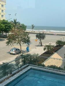 uitzicht op het strand vanaf het balkon van een gebouw bij Royal Hotel Sầm Sơn in Sầm Sơn
