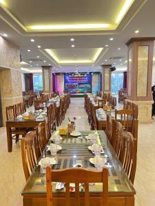 comedor con mesas largas y sillas de madera en Royal Hotel Sầm Sơn, en Sầm Sơn