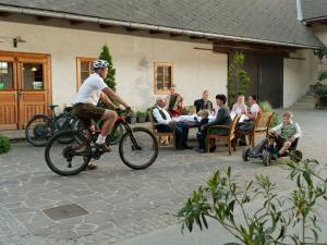 a man riding a bike in front of a group of people at Urlaub am Obsthof Pieber in Weiz