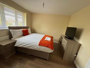 a small bedroom with a bed and a television at Cozy 4-bed House in Walmley in Birmingham
